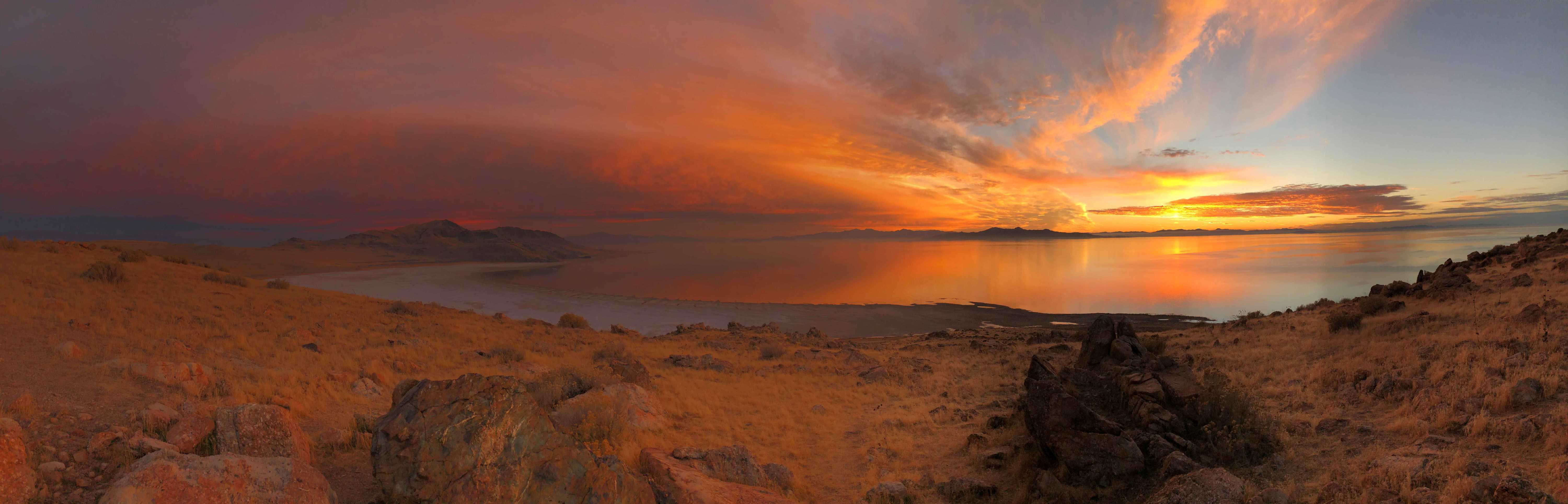 A panorama of sunset over the Great Salt Lake with strong orange
					and red hues.