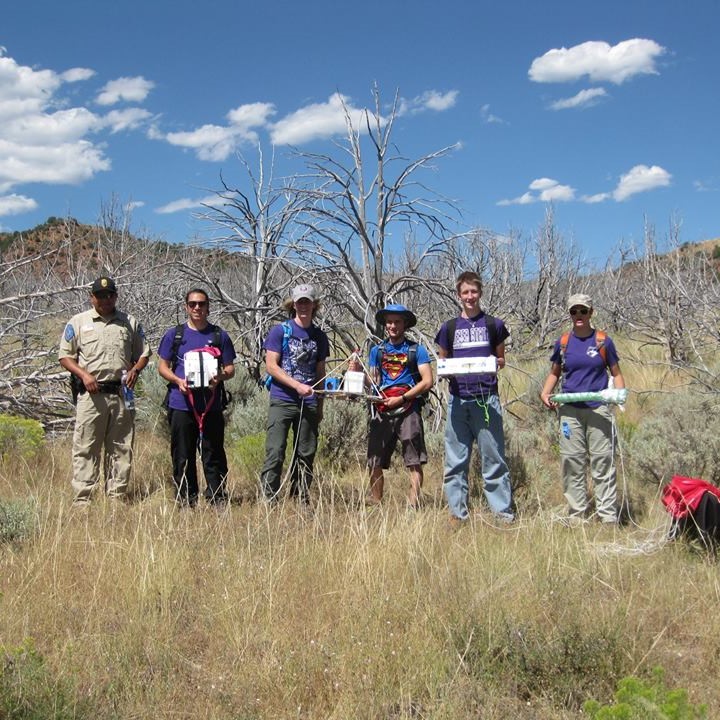A group of people holding recently recovered high altitude
								balloon research equipment.